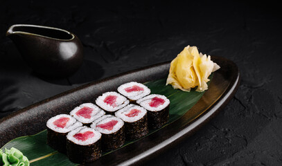 Elegant tuna sushi roll presentation on dark background
