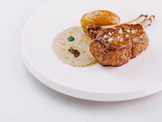 Gourmet lamb chop on elegant white plate