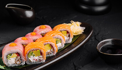 Gourmet sushi roll platter on black stone background