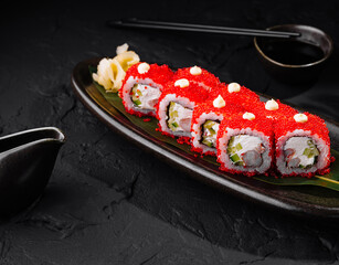 Gourmet sushi roll with red caviar on dark background