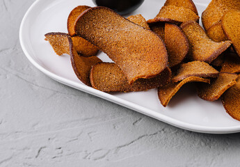 Crispy bread chips with dip on white plate