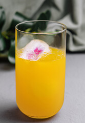 Refreshing orange cocktail with floral ice cubes