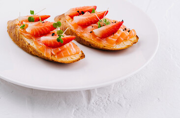 Gourmet smoked salmon toasts on white plate