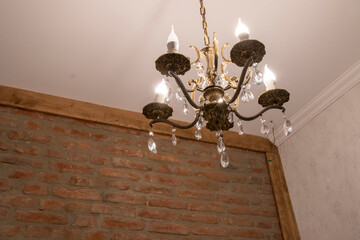 a chandelier in the corner of an old brick wall