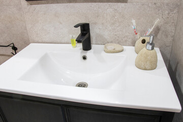 a white sink with soap, sponges and a dispenser
