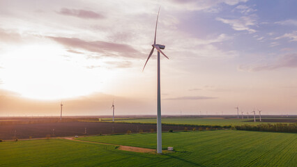 renewable eco energy on sunset green field.Close up high wind turbine generation electricity