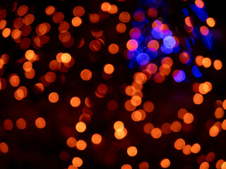 The image is a blurry, colorful background of orange and blue lights