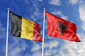 3d illustration. Belgium and Albania Flag waving in sky. High detailed waving flag. 3D render. Waving in sky. Flags fluttered in the cloudy sky.