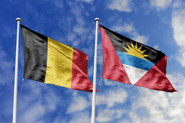 3d illustration. Belgium and Antigua and Barbuda Flag waving in sky. High detailed waving flag. 3D render. Waving in sky. Flags fluttered in the cloudy sky.