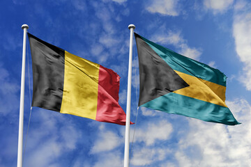 3d illustration. Belgium and The Bahamas Flag waving in sky. High detailed waving flag. 3D render. Waving in sky. Flags fluttered in the cloudy sky.