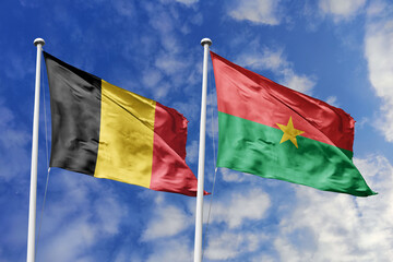 3d illustration. Belgium and Burkina Faso Flag waving in sky. High detailed waving flag. 3D render. Waving in sky. Flags fluttered in the cloudy sky.