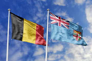 3d illustration. Belgium and Fiji Flag waving in sky. High detailed waving flag. 3D render. Waving in sky. Flags fluttered in the cloudy sky.