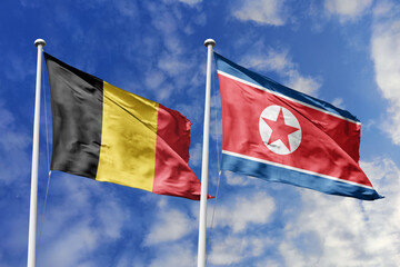 3d illustration. Belgium and North Korea Flag waving in sky. High detailed waving flag. 3D render. Waving in sky. Flags fluttered in the cloudy sky.