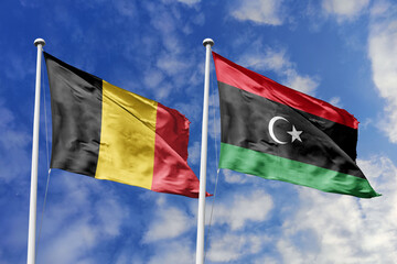 3d illustration. Belgium and Libya Flag waving in sky. High detailed waving flag. 3D render. Waving in sky. Flags fluttered in the cloudy sky.