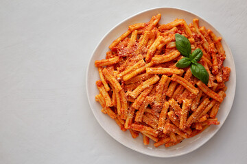 Homemade Italian Casarecce Pasta with Creamy Tomato Sauce, top view. Flat lay, overhead, from above. Copy space.