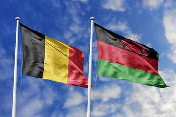 3d illustration. Belgium and Malawi Flag waving in sky. High detailed waving flag. 3D render. Waving in sky. Flags fluttered in the cloudy sky.