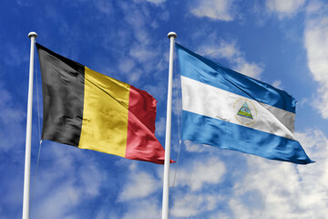 3d illustration. Belgium and Nicaragua Flag waving in sky. High detailed waving flag. 3D render. Waving in sky. Flags fluttered in the cloudy sky.