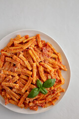 Homemade Italian Casarecce Pasta with Creamy Tomato Sauce, top view. Flat lay, overhead, from above. Copy space.