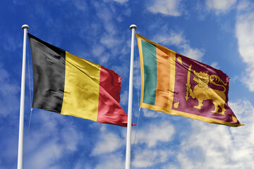 3d illustration. Belgium and Sri Lanka Flag waving in sky. High detailed waving flag. 3D render. Waving in sky. Flags fluttered in the cloudy sky.
