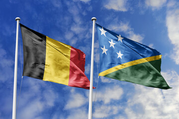 3d illustration. Belgium and Solomon Islands Flag waving in sky. High detailed waving flag. 3D render. Waving in sky. Flags fluttered in the cloudy sky.