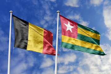 3d illustration. Belgium and Togo Flag waving in sky. High detailed waving flag. 3D render. Waving...
