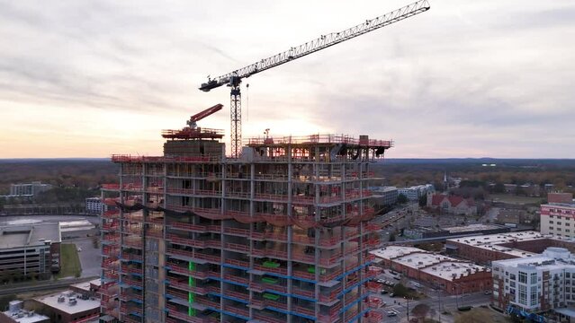 Drone footage of a construction site of an urban building in Durham city at sunset in NC, USA