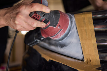 Person using a machine to polish automotive lighting on a car headlight