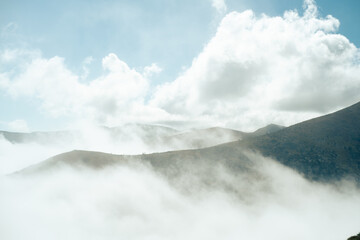 Mountain peaks emerging from a sea of clouds under a blue sky