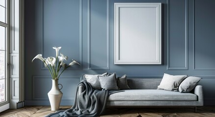A large, blank white frame hangs on the wall above an elegant grey sofa in a modern living room with blue walls and a wooden floor