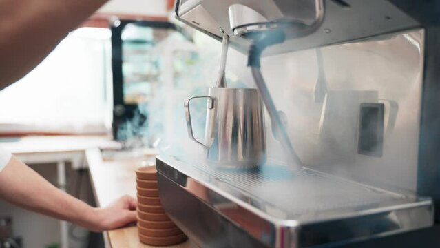Senior Asian man barista is using a coffee maker. Bakery cafe and coffee shop small business owner concept