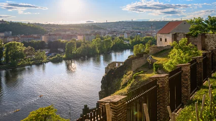 Fototapeten Prag A view of the Vltava River from Prague's Vyšehrad at sunset with the vineyard in the foreground and the historic walls.  © Premysl