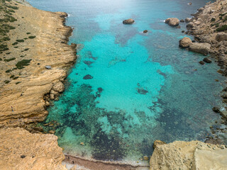 Aerial view of the rocky shore and turquoise waters. Cala Boquer beach, Mallorca
