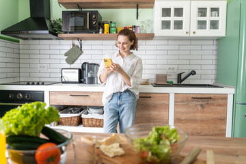 A woman using smart phone in kitchen
