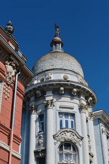 Neoclassic architecture, pink and blue building in Novi sad, Serbia. The facade of an old renovated building with columns on a sunny spring day.