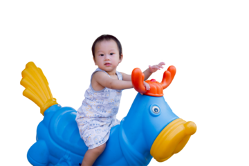 A cute little boy smiling while playing with a toy spring rocking horse in a playground. Happy kid in summer or spring time. Isolated background. Child aged 1.7 year old.