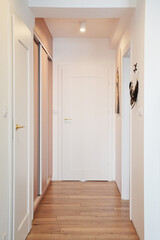 Korytarz w domu z drzwiami i włączonym oświetleniem natynkowym sufitowym