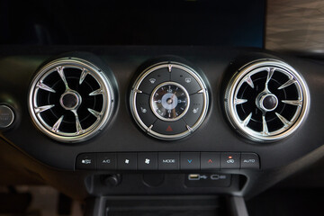 Closeup of car dashboard air vents near gear shift