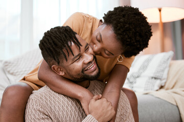 Couple, black woman and man in living room, kiss and hug for love, smile and romance in home to...