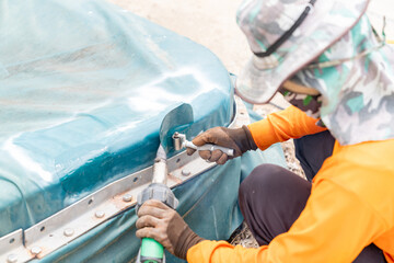 Worker use hot-wedge blower patch plastic canvas and stainless roller compress.