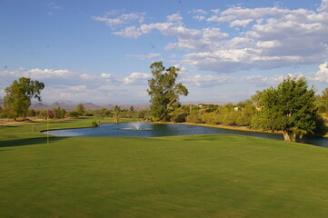 Scenic view from hilltop of golf course, mountains, and clear blue sky in Utah