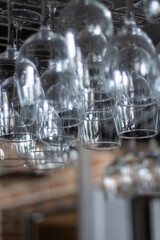 Stemware hanging from ceiling rack for elegant display in bar