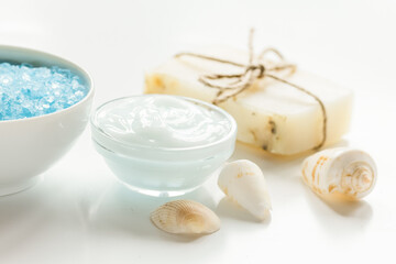 Home cosmetic with cream and blue sea salt on white background
