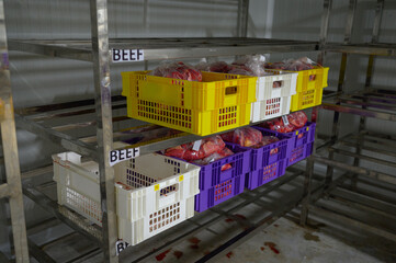 Beef in transparent bags inside colour crates in a cold storage room ready for processing
