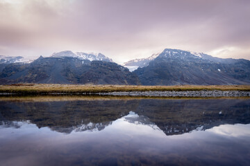 Scenic view of mountains reflected in a large body of water. Iceland