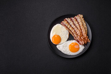 English breakfast with fried eggs, bacon, beans, tomatoes, spices and herbs