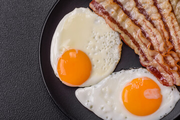 English breakfast with fried eggs, bacon, beans, tomatoes, spices and herbs