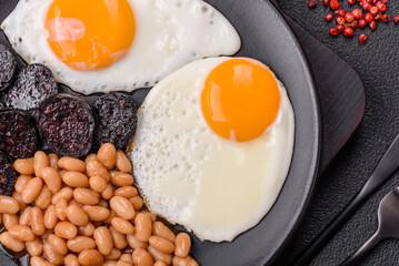 English breakfast with fried eggs, bacon, beans, tomatoes, spices and herbs