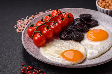 English breakfast with fried eggs, bacon, beans, tomatoes, spices and herbs