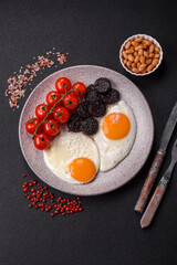 English breakfast with fried eggs, bacon, beans, tomatoes, spices and herbs