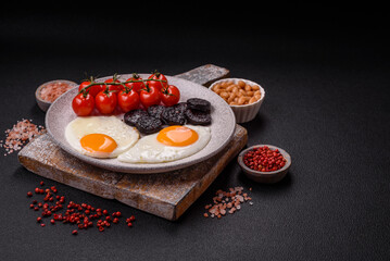 English breakfast with fried eggs, bacon, beans, tomatoes, spices and herbs